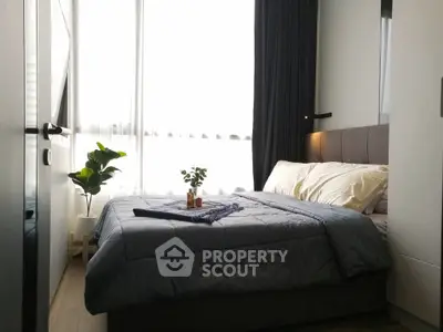 Cozy bedroom with modern decor and natural light, perfect for relaxation and comfort.