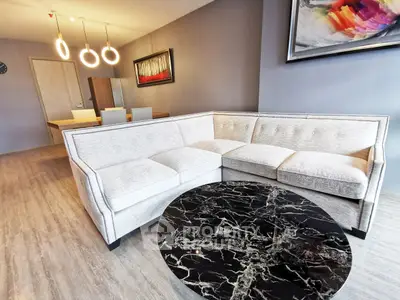 Modern living room with stylish sofa and marble coffee table in open layout apartment.