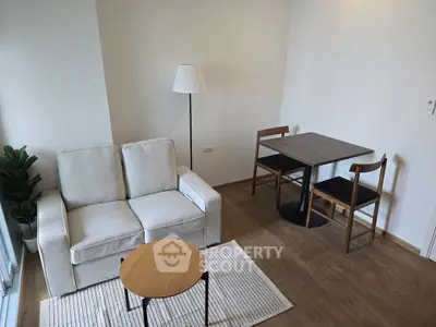 Cozy modern living room with white sofa, wooden floor, and dining area.