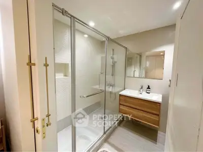 Modern bathroom with glass shower and sleek wooden vanity