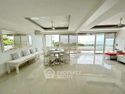 Spacious living room with ocean view and elegant dining area in luxury apartment.
