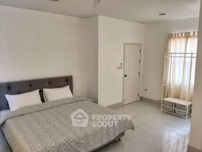 Spacious bedroom with minimalist decor and natural light