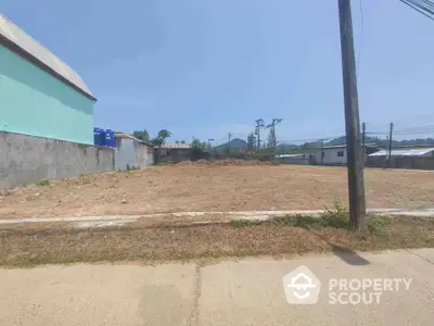 Expansive vacant lot in a developing area, perfect for constructing a dream home or investment property, with clear skies and potential for landscaping.