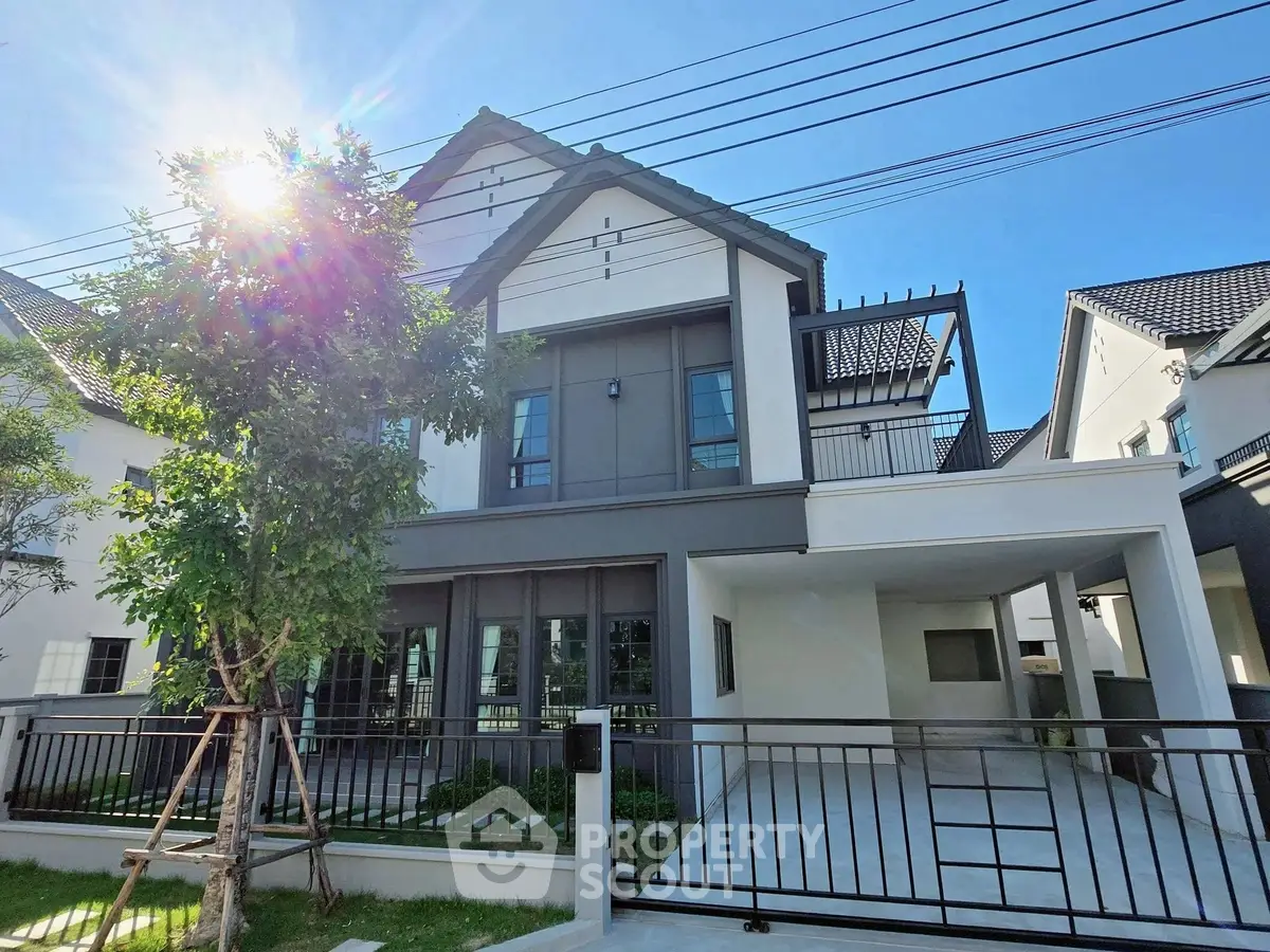 Modern two-story house with sleek design and spacious driveway in a sunny neighborhood.