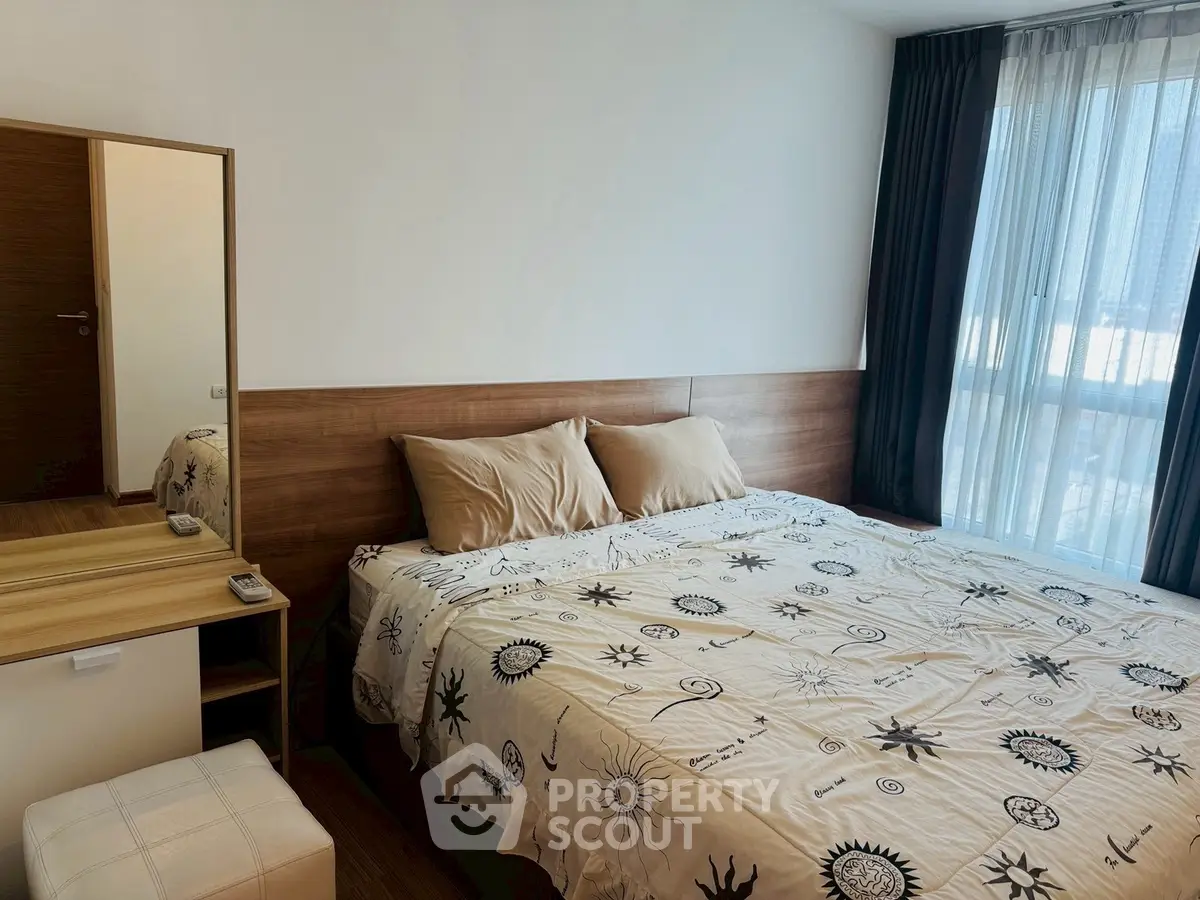 Cozy bedroom with stylish decor and large window for natural light