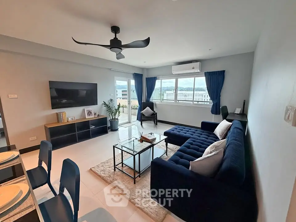Spacious modern living room with stylish furniture and large windows offering natural light.