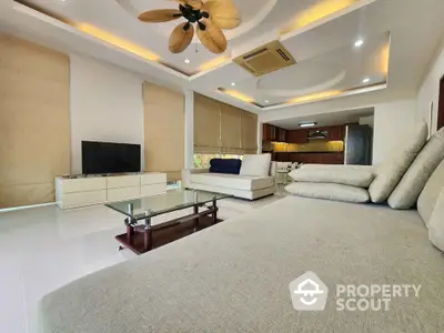 Spacious modern living room with elegant ceiling design and open kitchen layout.