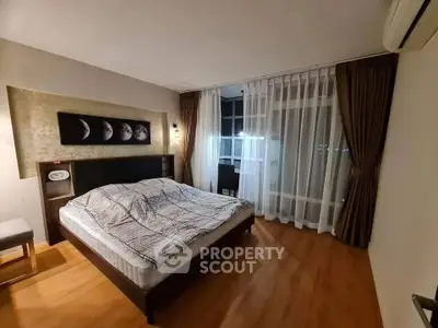 Spacious bedroom with modern decor and large window offering city views.