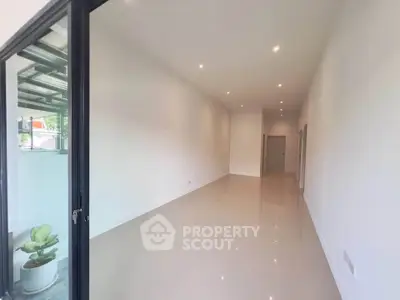 Spacious and bright interior with sleek tile flooring and modern lighting, perfect for versatile living space.