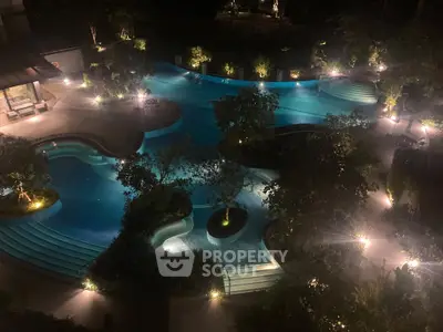 Luxurious night view of illuminated swimming pool with lush greenery