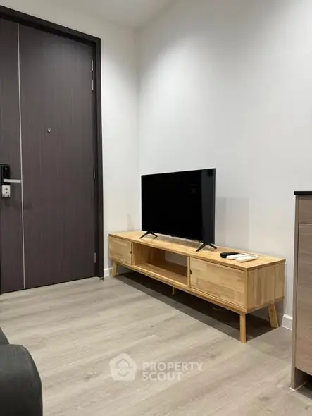 Modern living room with sleek TV stand and stylish wooden flooring.