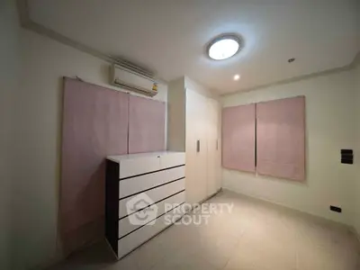 Spacious bedroom with modern wardrobe and air conditioning unit