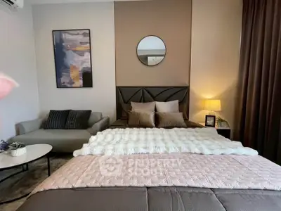 Stylish bedroom with modern decor and cozy ambiance, featuring a plush bed and elegant furnishings.