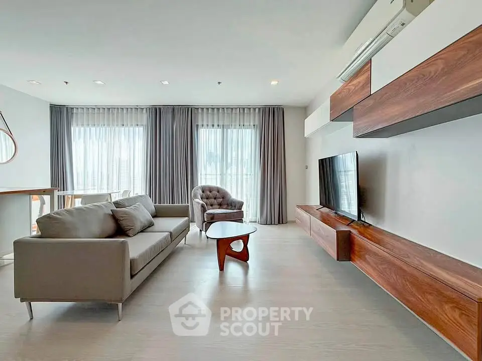 Spacious modern living room with elegant furniture and large windows for natural light.