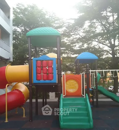Vibrant playground area in residential complex with colorful slides and climbing structures.