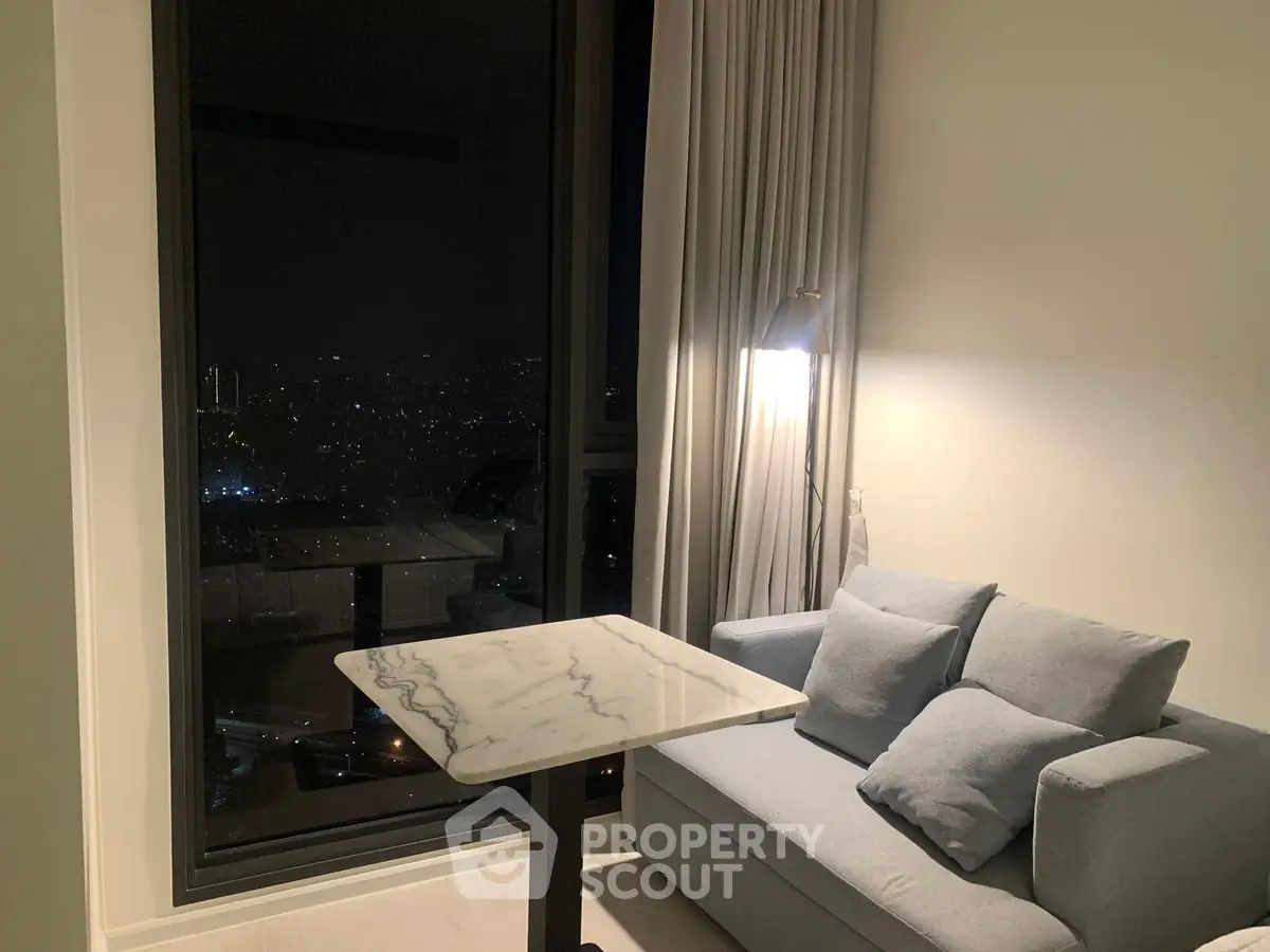 Cozy living room with city night view and elegant marble table.