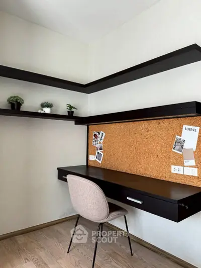 Modern study room with sleek black desk, corkboard, and floating shelves in minimalist design.