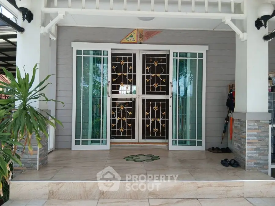 Charming entrance with decorative glass doors and tiled porch