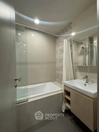 Modern bathroom with bathtub and sleek vanity in contemporary design.