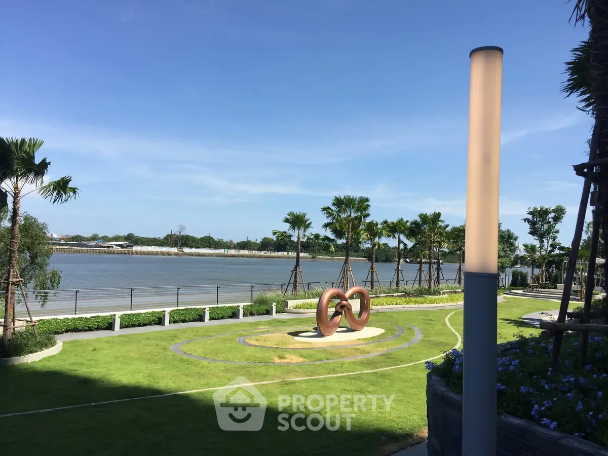 Stunning riverside garden view with modern sculpture and lush greenery