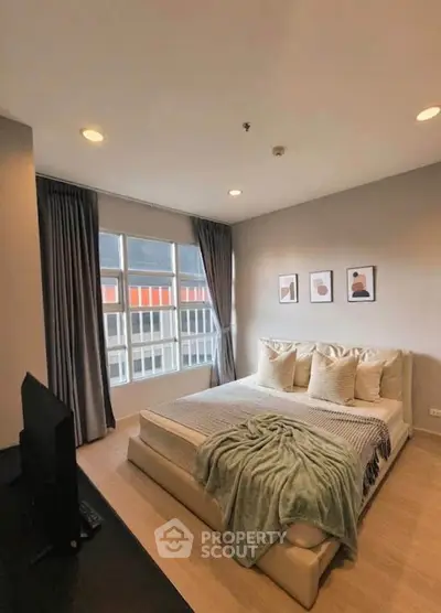 Spacious modern bedroom with large windows and stylish decor in a contemporary apartment.