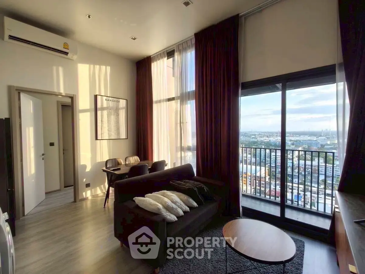 Stunning high-rise living room with floor-to-ceiling windows and city view balcony.