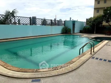 Luxurious rooftop pool with city views in modern residential building.