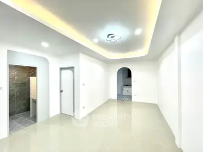 Modern minimalist living room with recessed lighting and sleek tile flooring