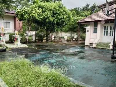 Charming residential property with spacious outdoor area and lush greenery, perfect for family living.