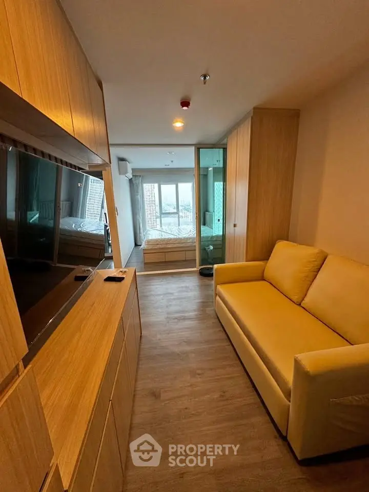 Modern studio apartment with cozy living area and large window view.