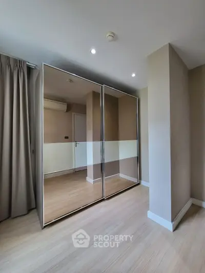Spacious bedroom with mirrored closet and modern design