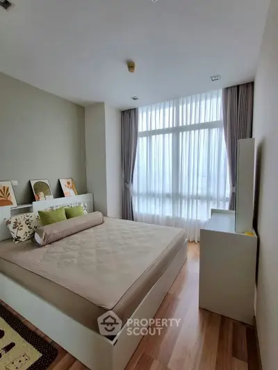 Modern bedroom with large window and stylish decor in a cozy apartment