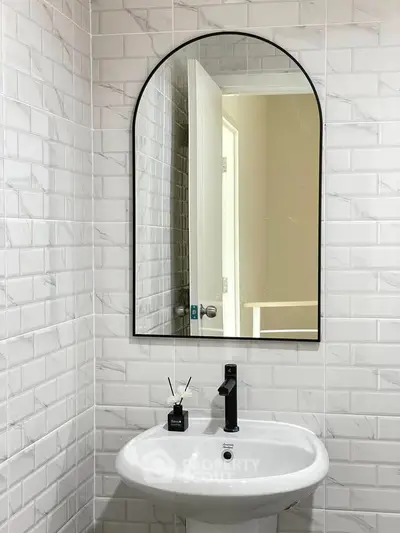 Modern bathroom with stylish sink and elegant arched mirror