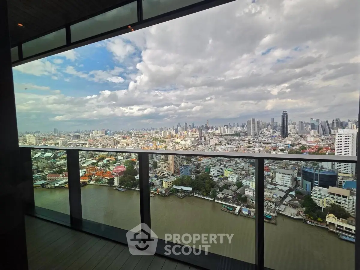 Stunning cityscape view from high-rise balcony overlooking river and skyline.