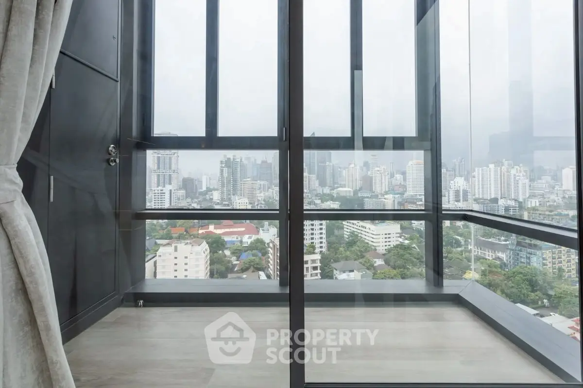 Stunning cityscape view from modern high-rise apartment with floor-to-ceiling windows.