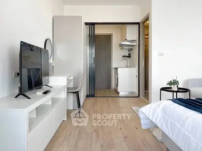 Modern studio apartment with sleek design and open layout, featuring a cozy living area and compact kitchen.
