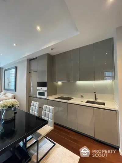 Modern kitchen with sleek cabinetry and integrated appliances in luxury apartment.