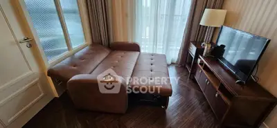 Cozy living room with sofa bed and modern TV setup, perfect for relaxation and entertainment.