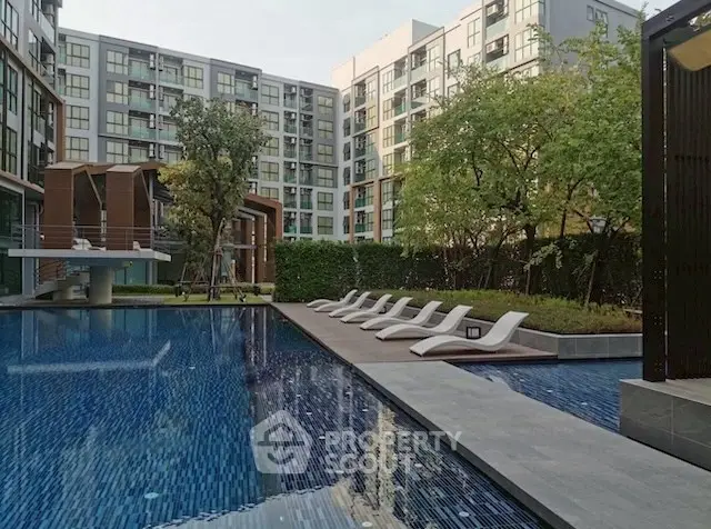 Modern apartment complex with luxurious pool and stylish lounge chairs