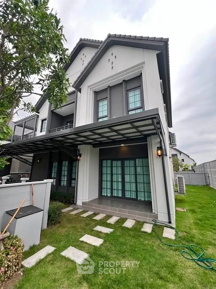 Modern two-story house with spacious garden and elegant facade, perfect for family living.