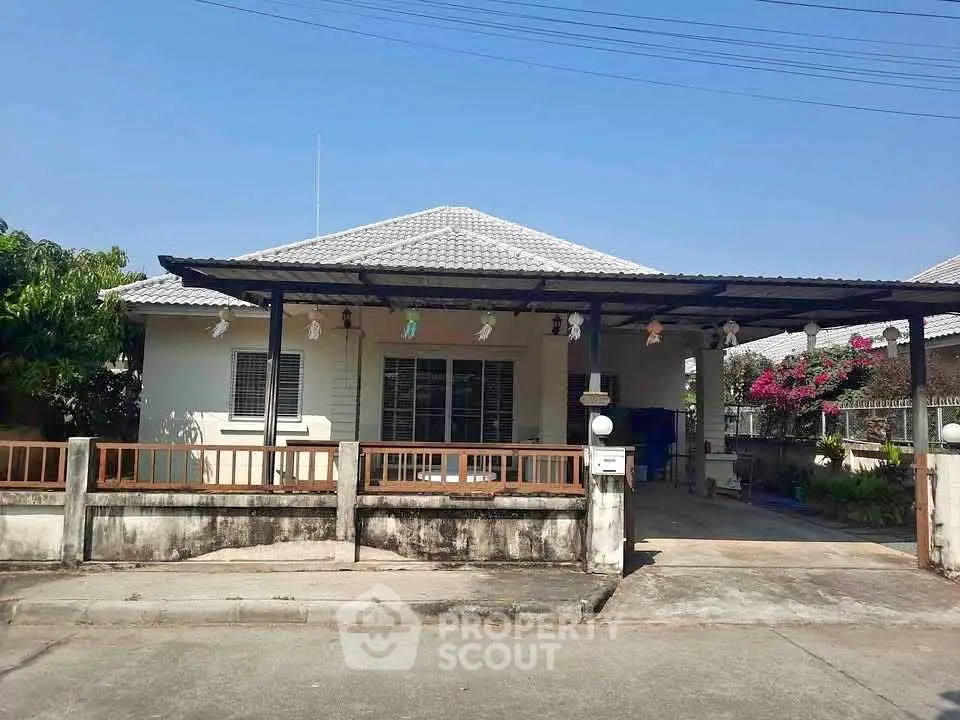 Charming single-story house with a spacious driveway and well-maintained garden, perfect for family living.