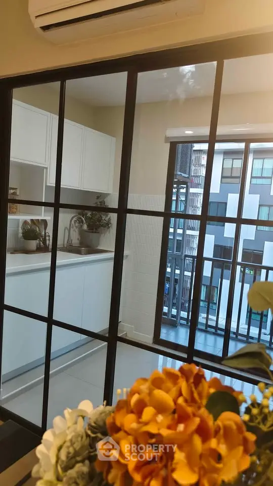 Modern kitchen with open layout and balcony view in urban apartment