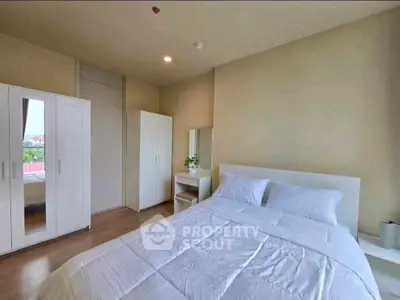 Spacious bedroom with modern furniture and natural light in a stylish apartment.