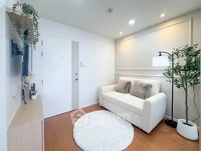 Cozy modern living room with white sofa, wall-mounted TV, and stylish decor.