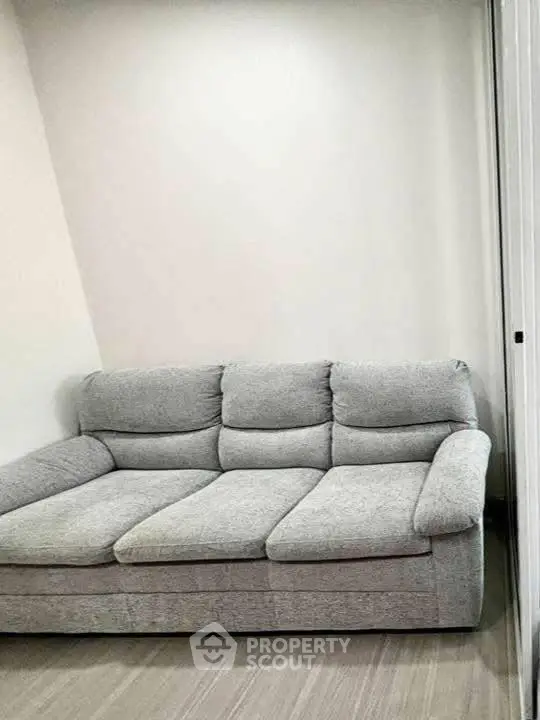 Cozy gray sofa in a modern living room with neutral tones.