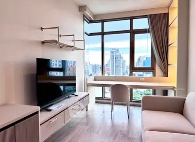 Modern living room with city view, featuring sleek furniture and large windows for natural light.