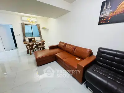 Spacious living room with modern leather sofas and elegant dining area, perfect for family gatherings.