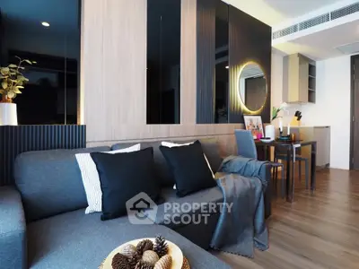 Modern living room with stylish decor and open layout, featuring a cozy gray sofa and elegant dining area.