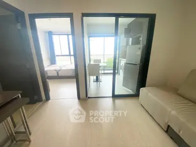 Modern apartment with open layout, featuring a cozy living area and a bright bedroom with balcony access.