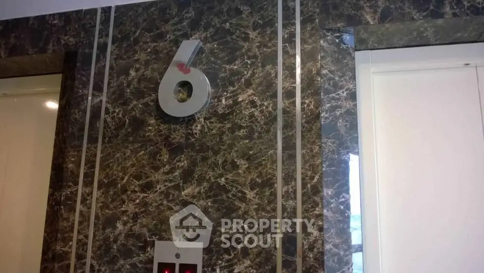 Elegant elevator lobby with marble walls and modern design on the sixth floor.